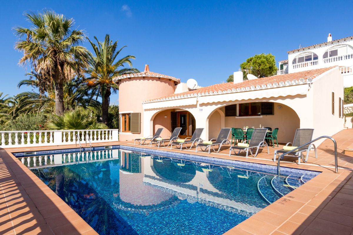 Immaculate residence with stunning views, stylish living room, and inviting pool area near Son Bou beach.